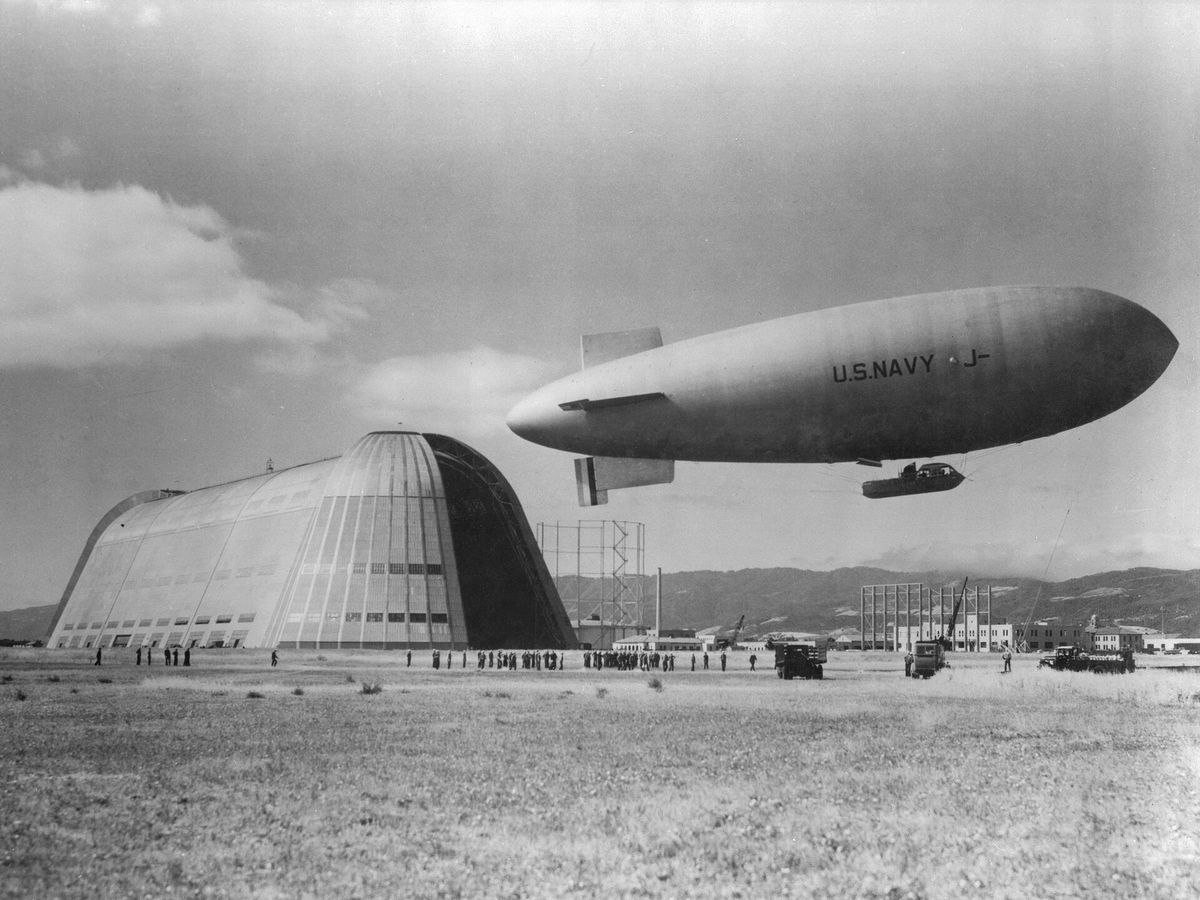 A Navy blimp flying over Hangar One around 1934